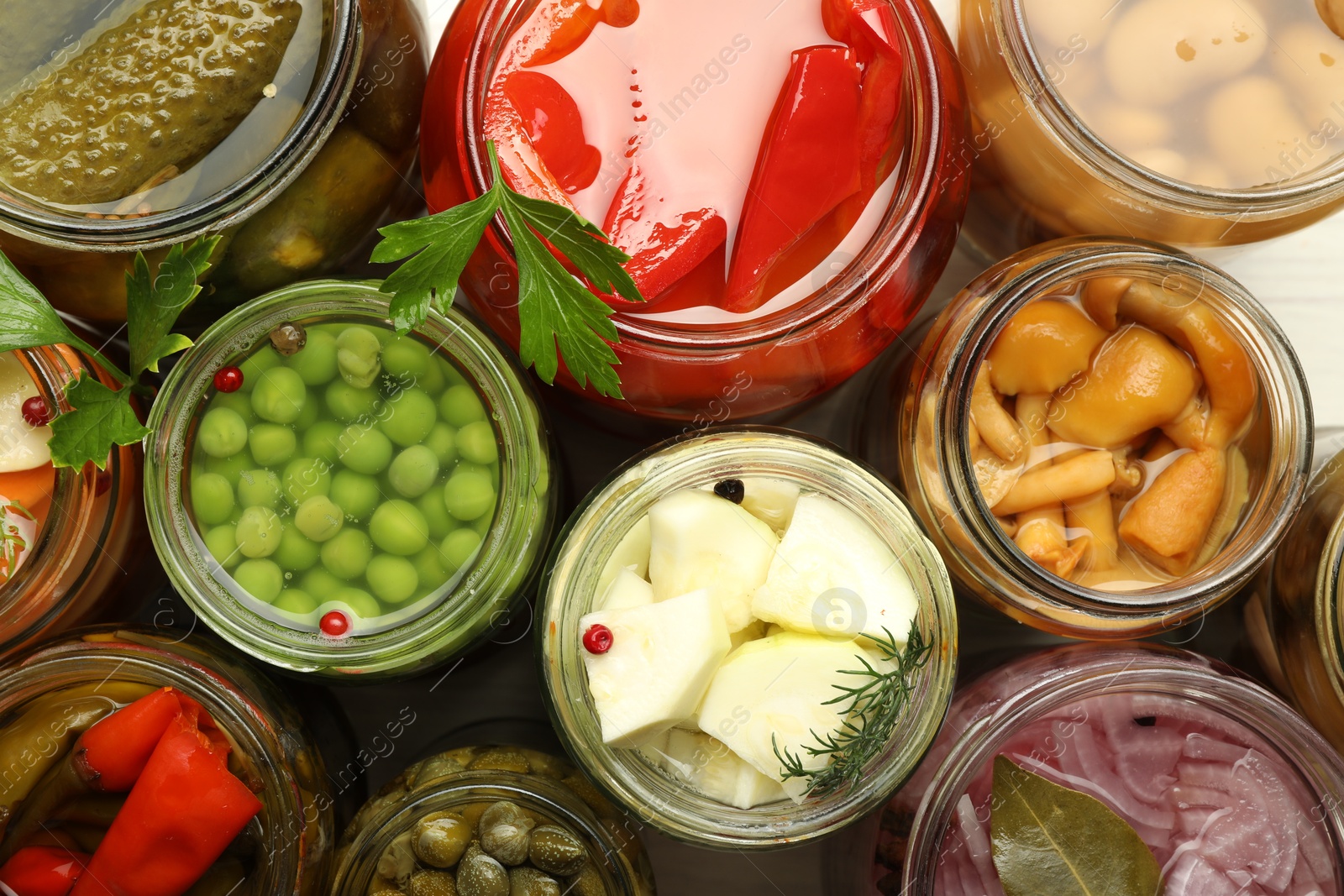 Photo of Different pickled products in jars on table, top view