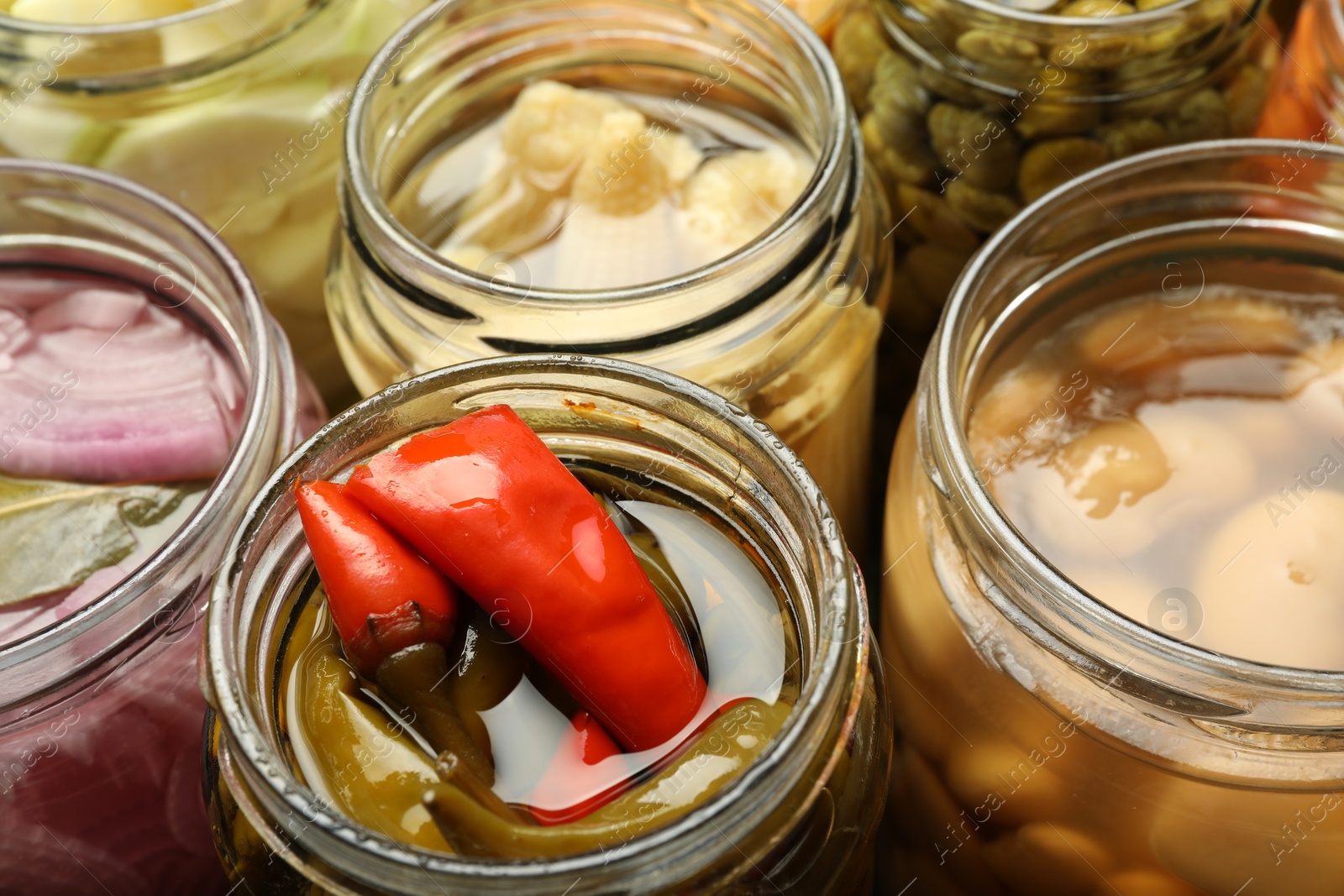 Photo of Different pickled products in jars, closeup view