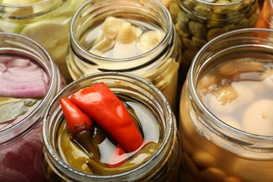 Photo of Different pickled products in jars, closeup view