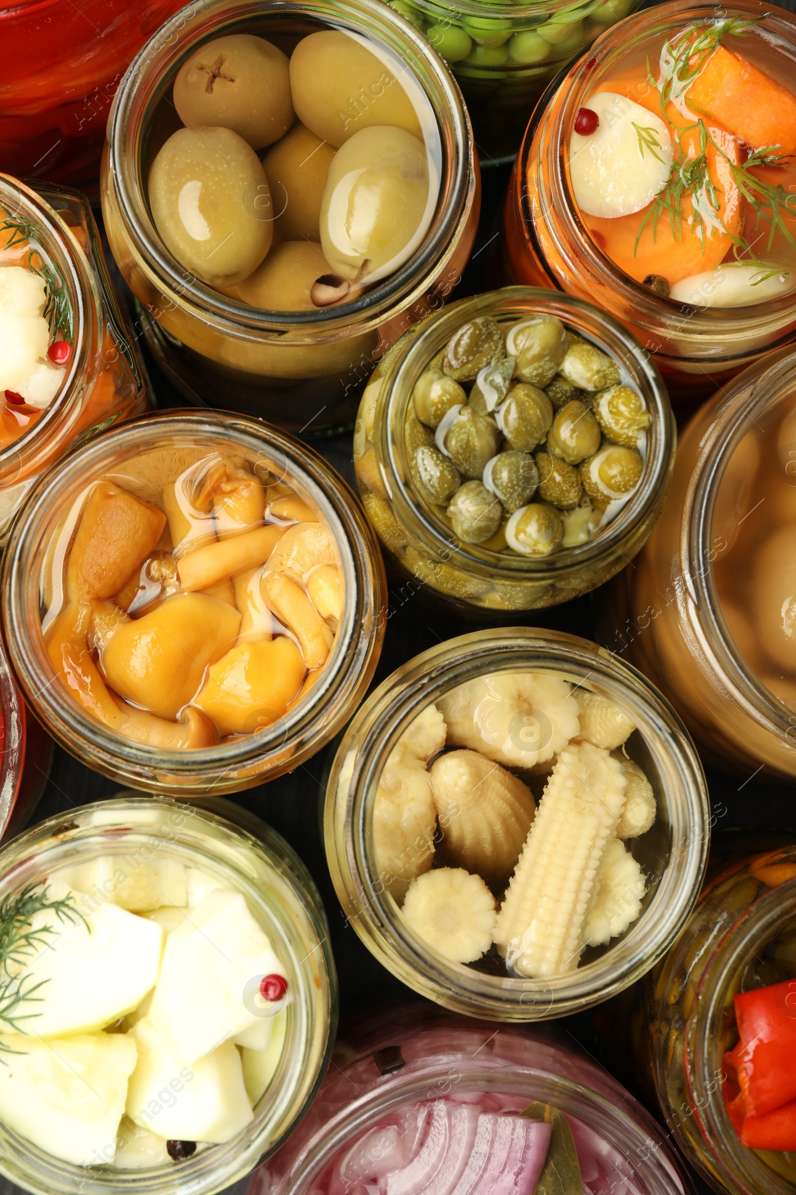 Photo of Different pickled products in jars on table, top view