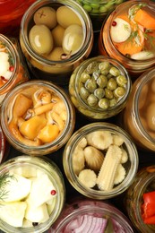 Photo of Different pickled products in jars on table, top view