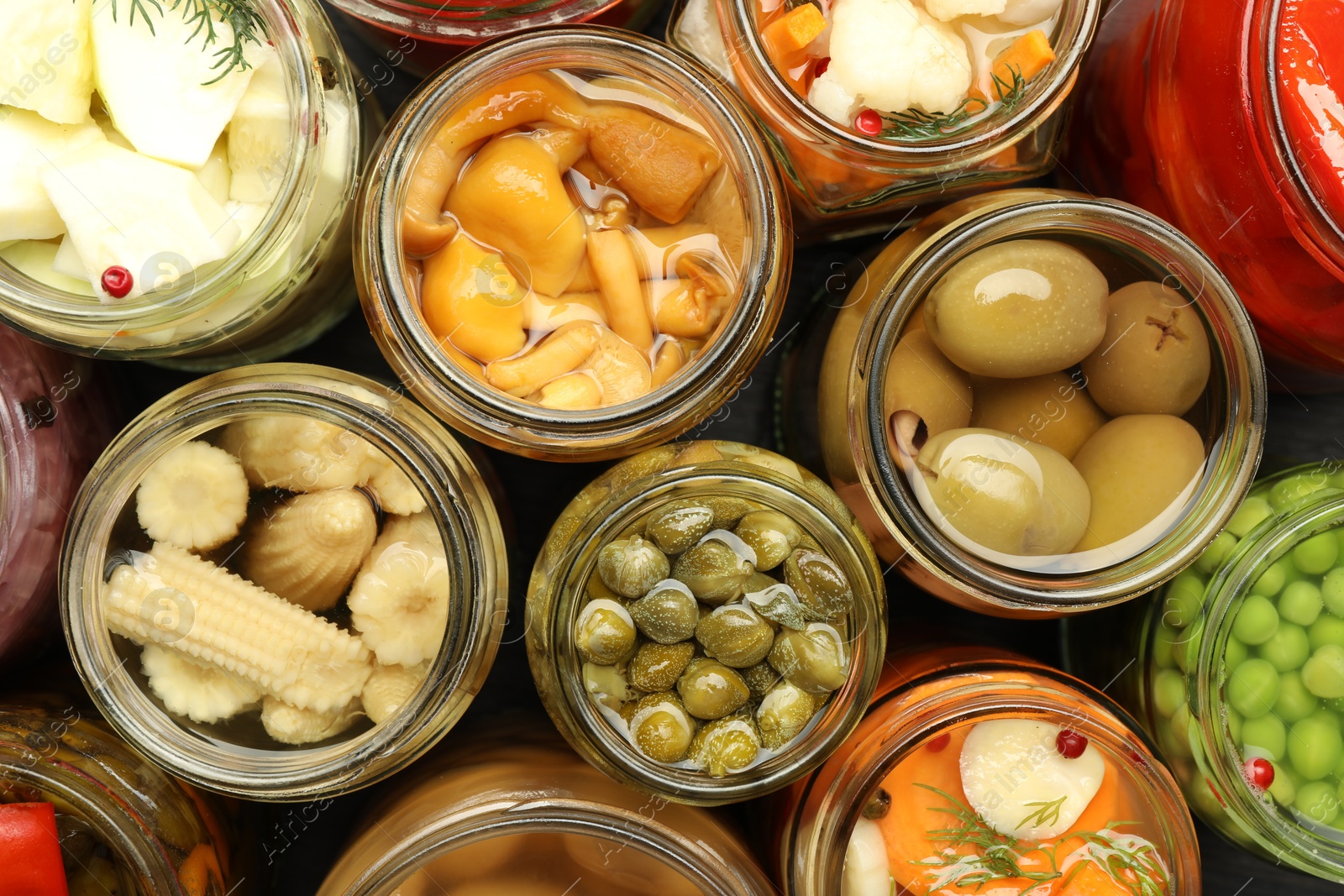 Photo of Different pickled products in jars on table, top view