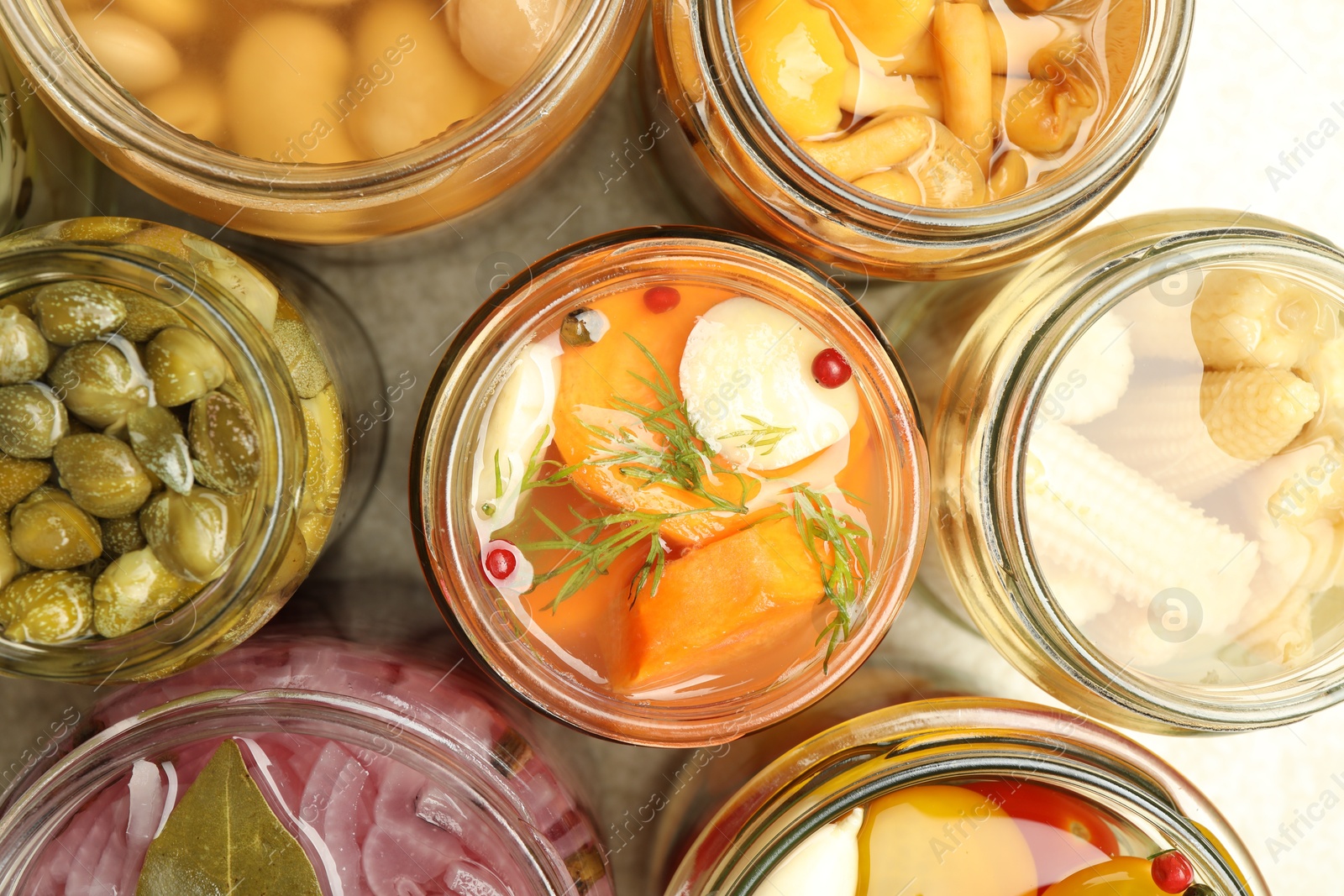 Photo of Different pickled products in jars on table, top view