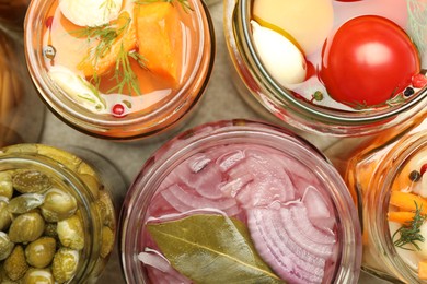 Photo of Different pickled products in jars on table, top view