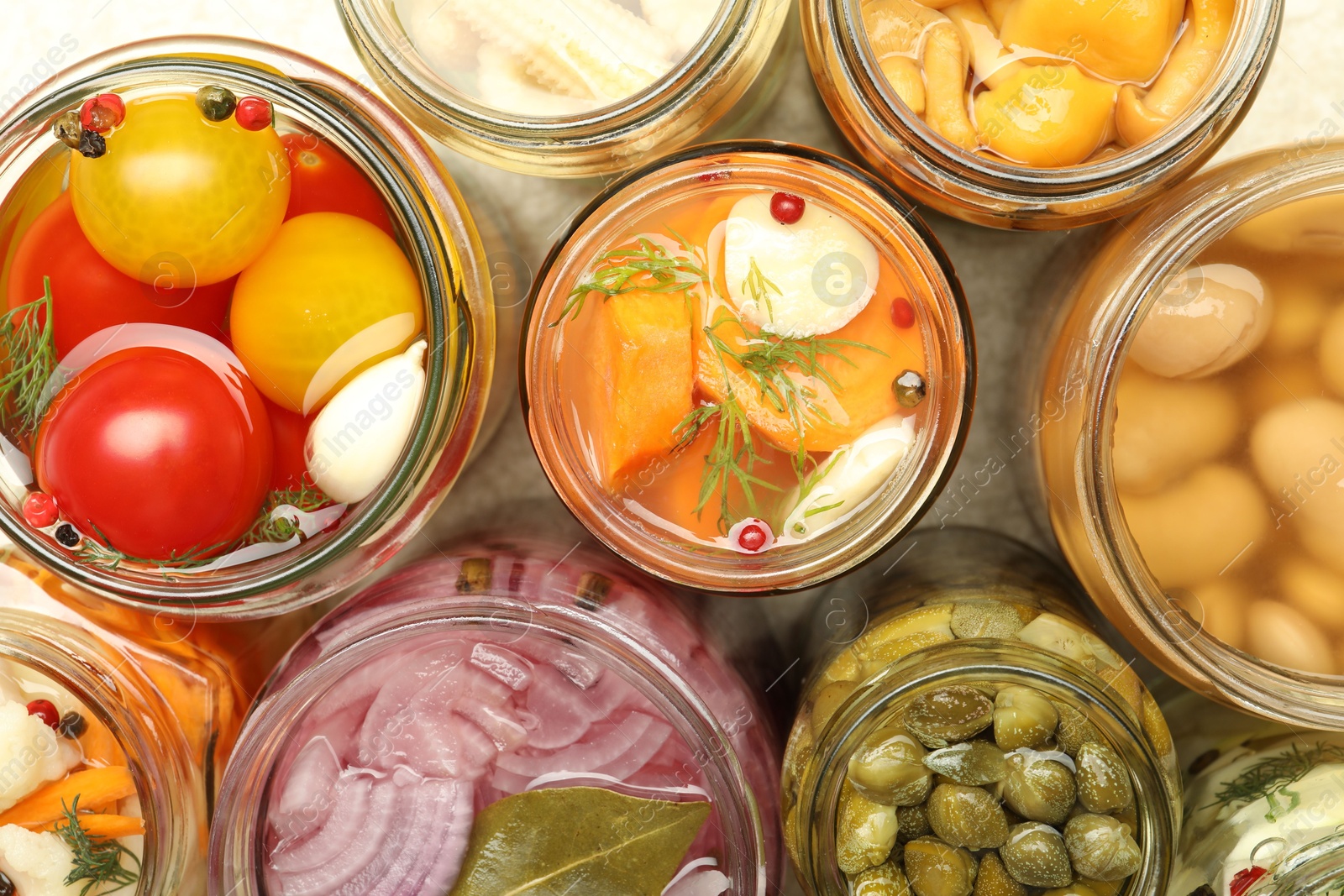 Photo of Different pickled products in jars on table, top view