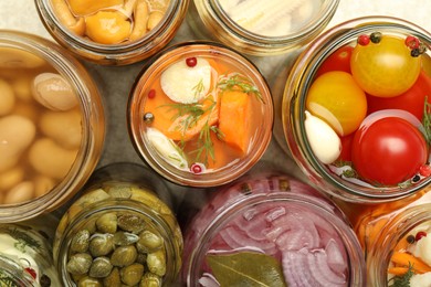 Photo of Different pickled products in jars on table, top view