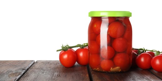 Photo of Tasty pickled tomatoes in jar and fresh vegetables on wooden table against white background. Space for text