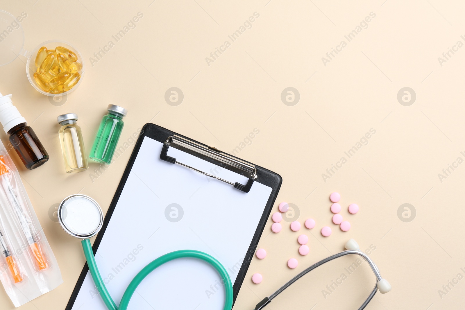 Photo of Pharmacist concept. Flat lay composition with clipboard, stethoscope and pills on beige background, space for text