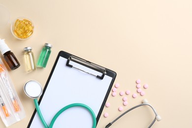 Pharmacist concept. Flat lay composition with clipboard, stethoscope and pills on beige background, space for text