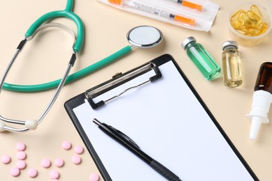 Photo of Pharmacist concept. Clipboard, stethoscope, vials and pills on beige background, above view