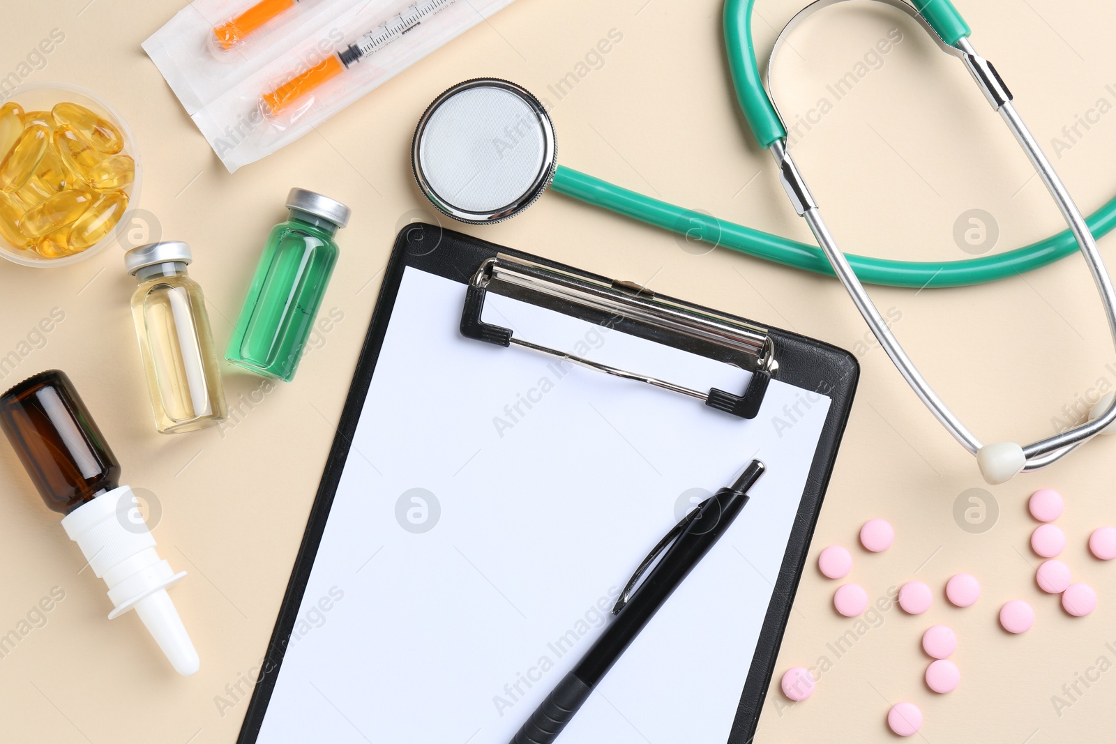 Photo of Pharmacist concept. Flat lay composition with clipboard and pills on beige background