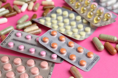 Photo of Pharmacist concept. Many different pills on pink background, closeup