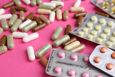 Photo of Pharmacist concept. Many different pills on pink background, closeup