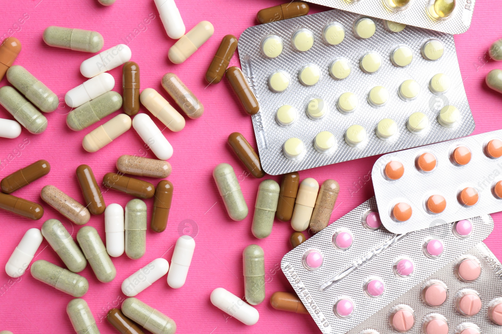 Photo of Pharmacist concept. Flat lay composition with many different pills on pink background