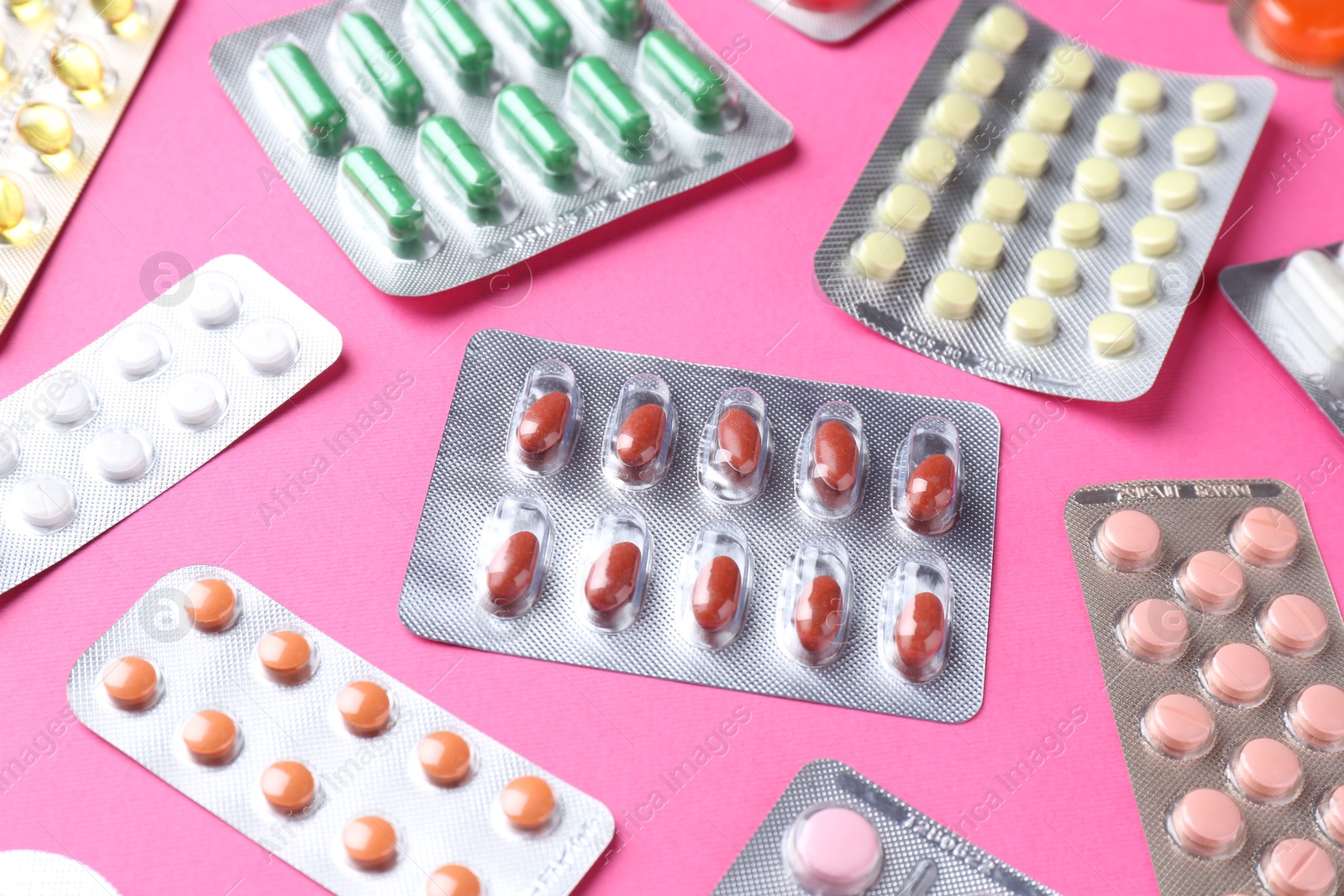 Photo of Pharmacist concept. Many different pills on pink background