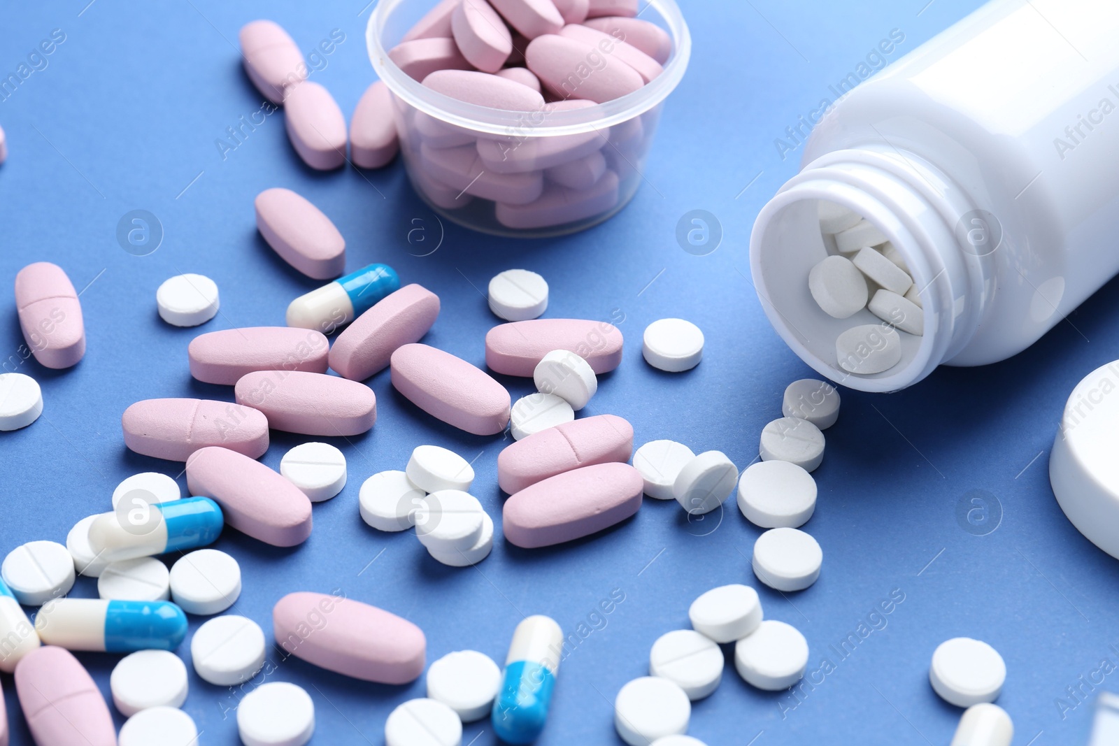 Photo of Pharmacist concept. Many different pills on blue background, closeup