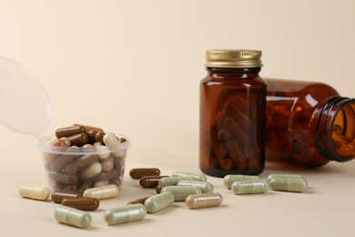 Photo of Pharmacist. Many different pills in plastic container and bottles on beige background