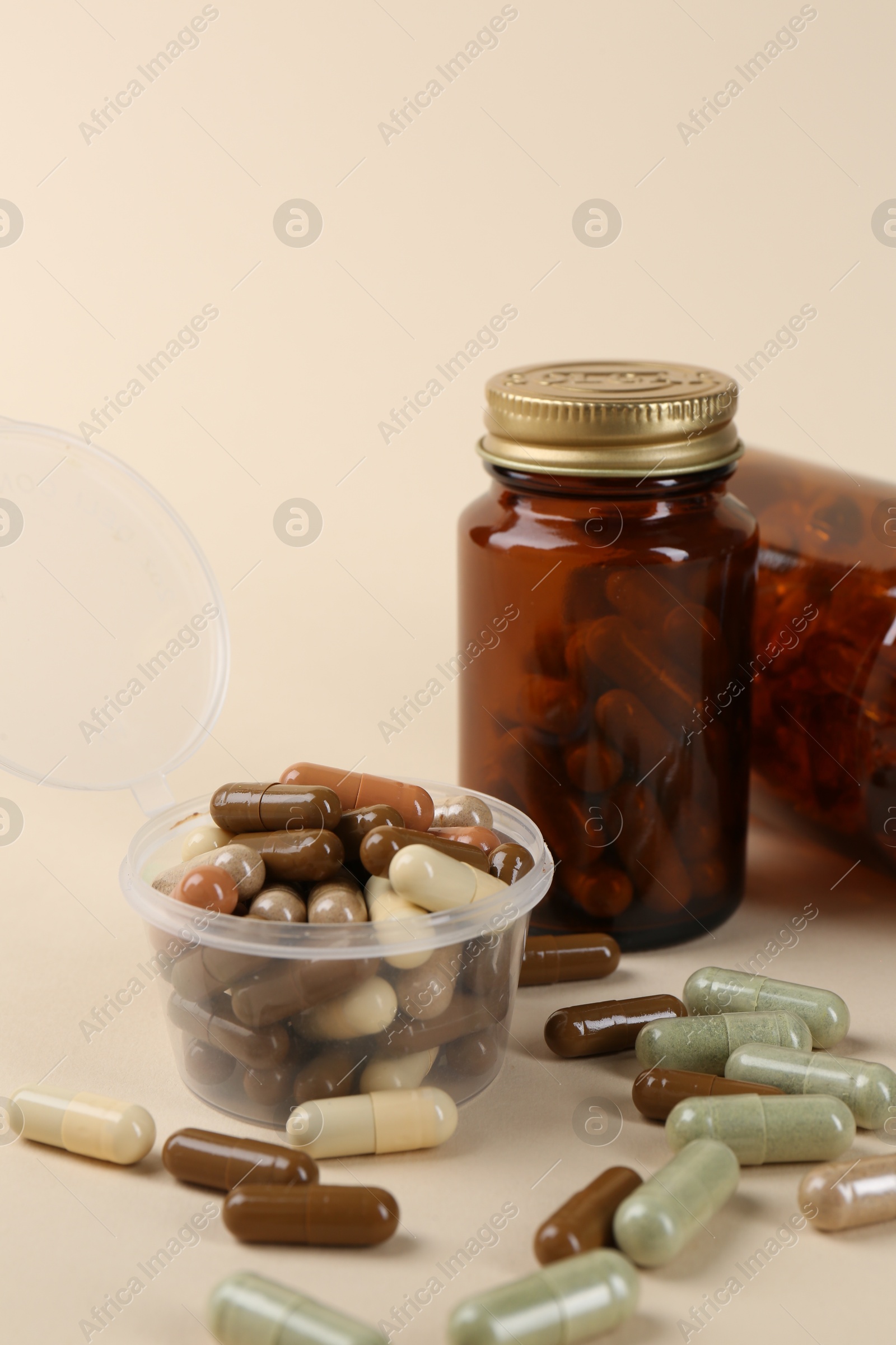 Photo of Pharmacist. Many different pills in plastic container and bottles on beige background