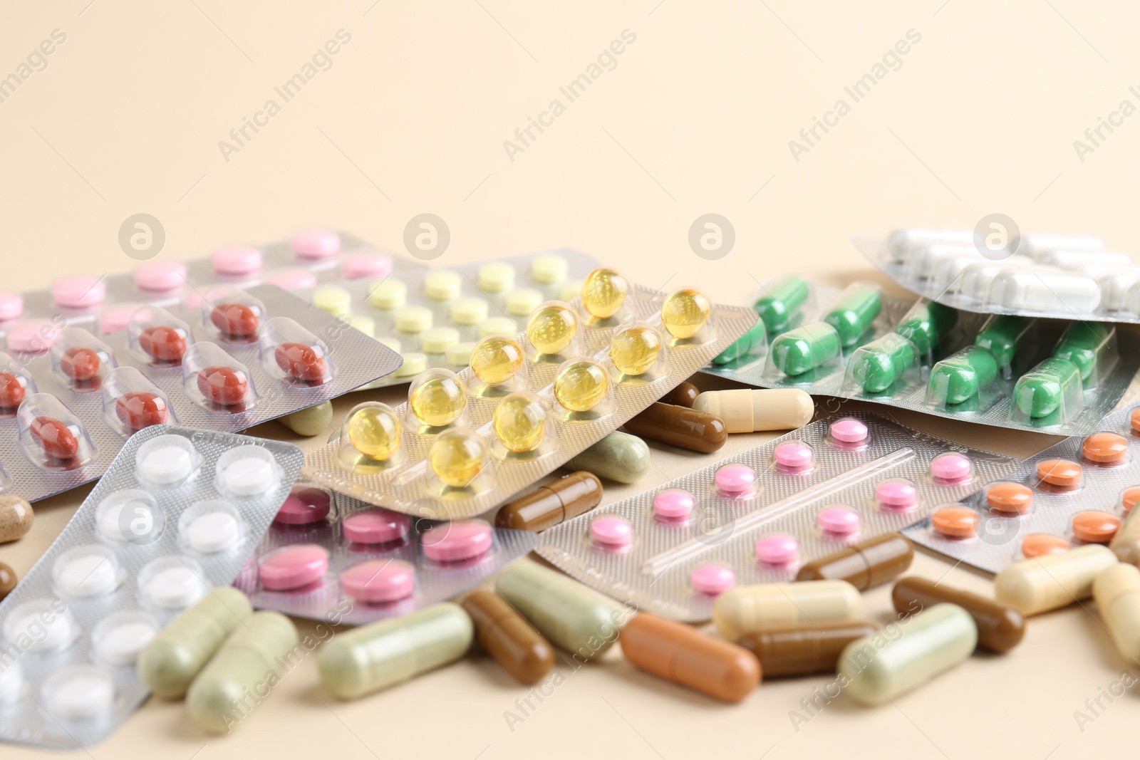 Photo of Pharmacist. Many different pills on beige background, closeup