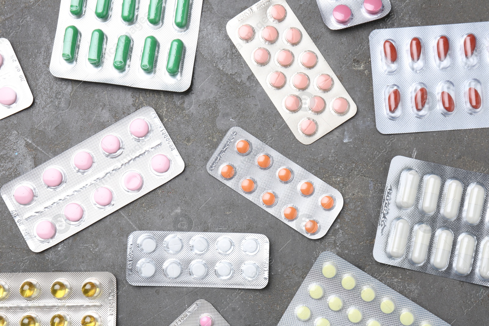 Photo of Pharmacist. Many different pills on grey table, flat lay