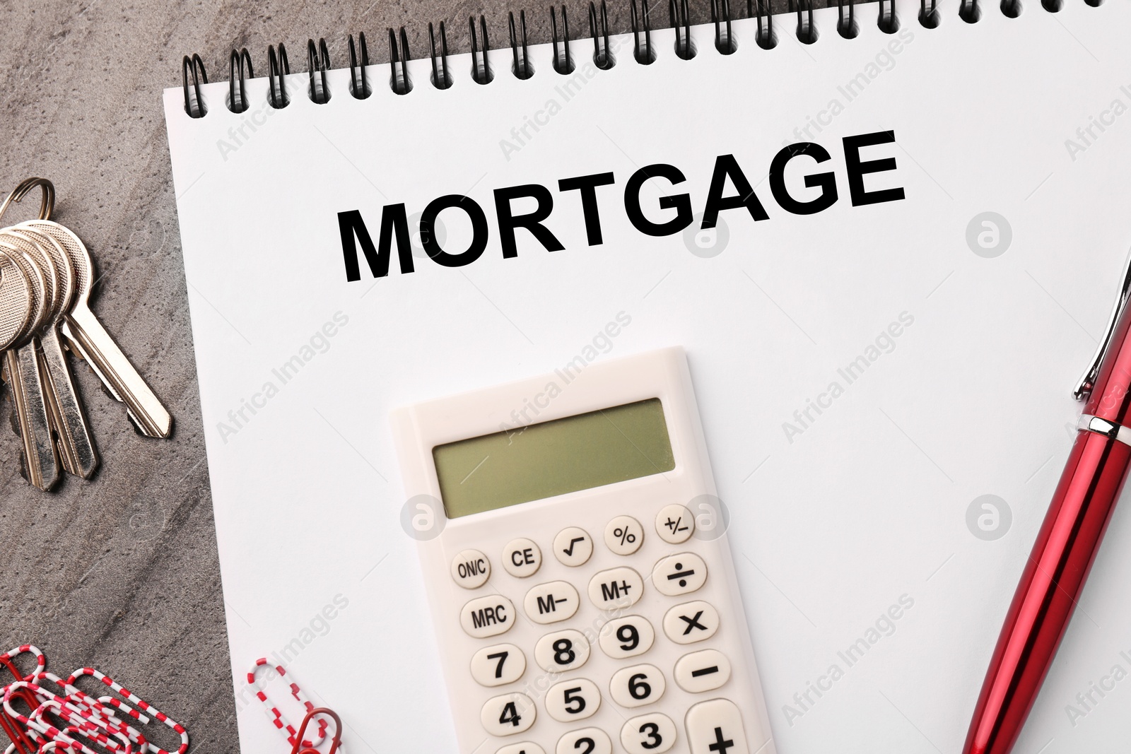 Image of Word Mortgage in notebook, calculator and keys on wooden table, flat lay