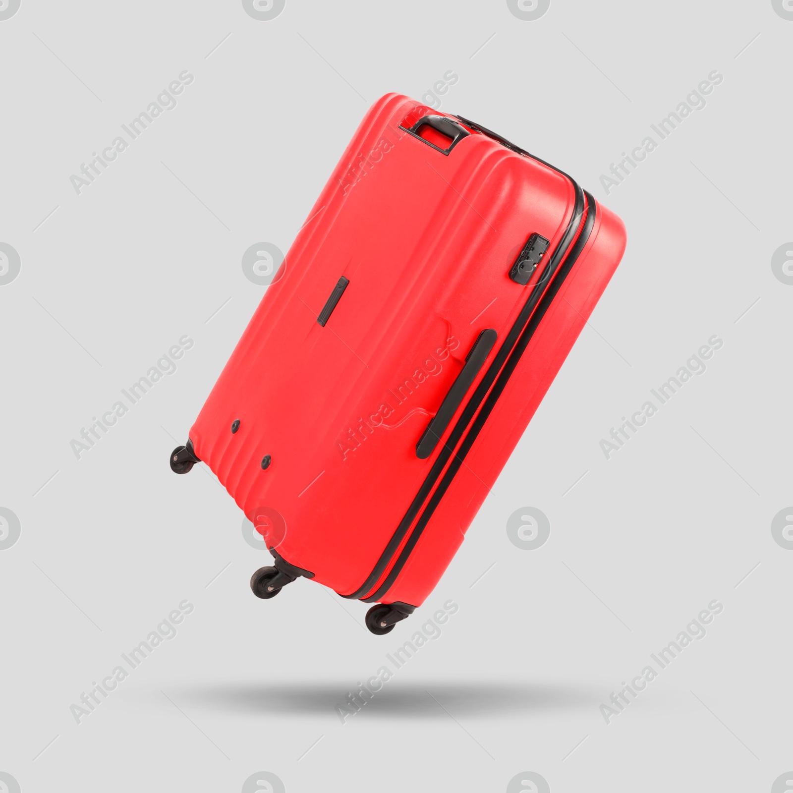 Image of Red suitcase in air on light grey background