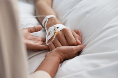 Coma patient. Woman near his unconscious son in hospital, closeup