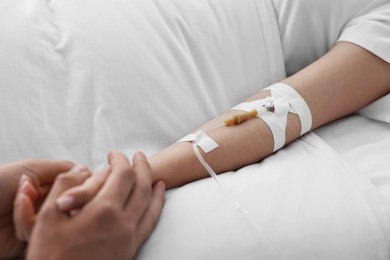 Photo of Coma patient. Man near his unconscious wife in hospital, selective focus