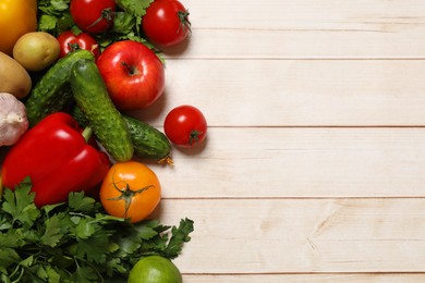 Photo of Different vegetarian products on light wooden table, top view. Space for text