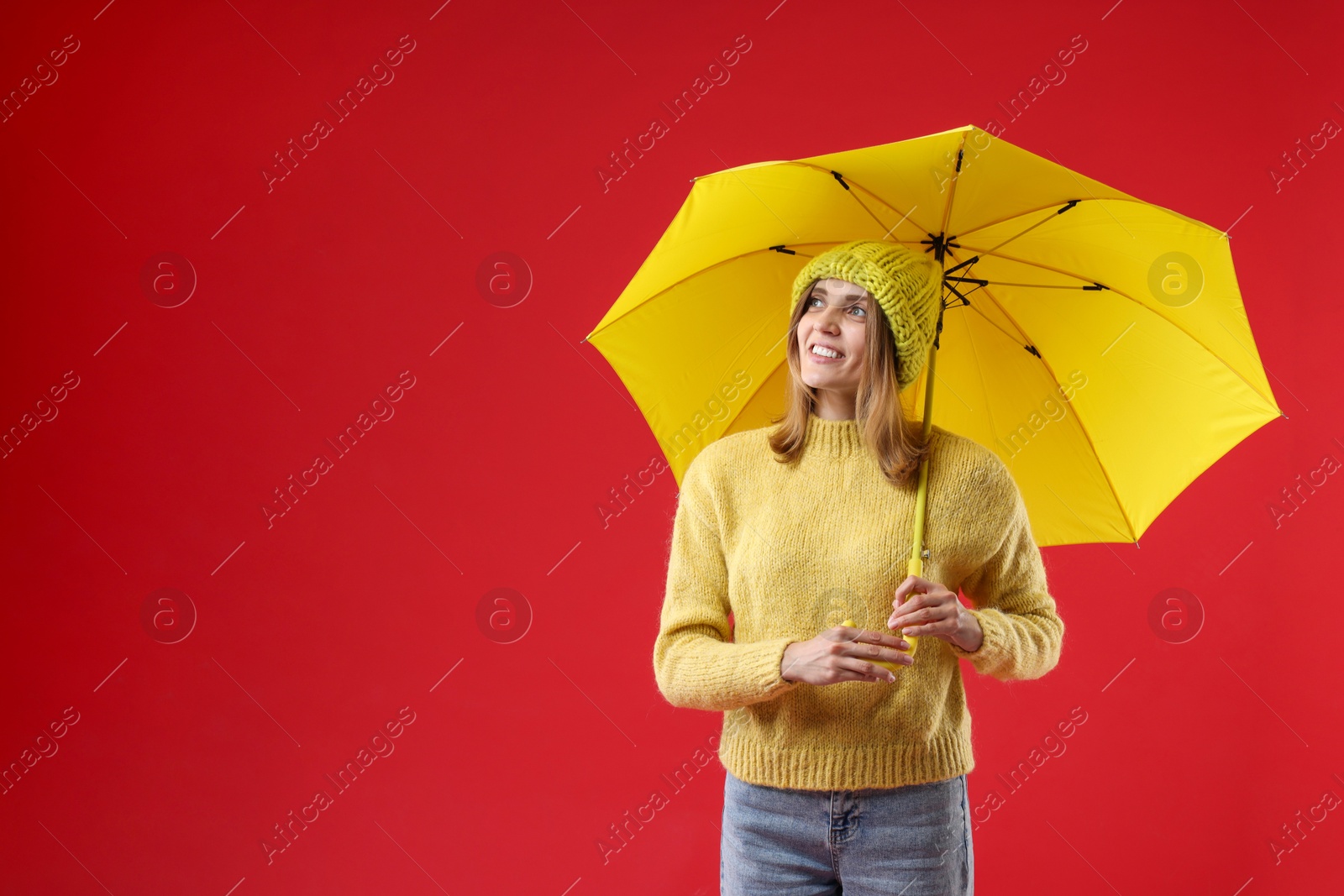 Photo of Woman with yellow umbrella on red background, space for text