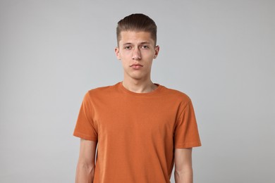 Portrait of handsome young man on light grey background