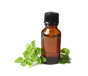 Essential oil in bottle and oregano leaves isolated on white