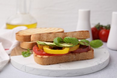 Photo of Tasty sandwiches with grilled vegetables on light table, closeup