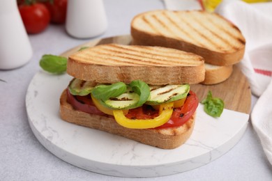 Photo of Tasty sandwiches with grilled vegetables on light table, closeup