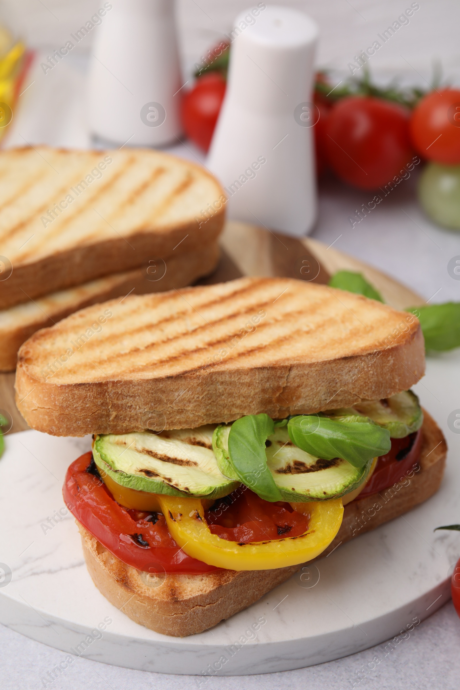 Photo of Tasty sandwiches with grilled vegetables on light table, closeup