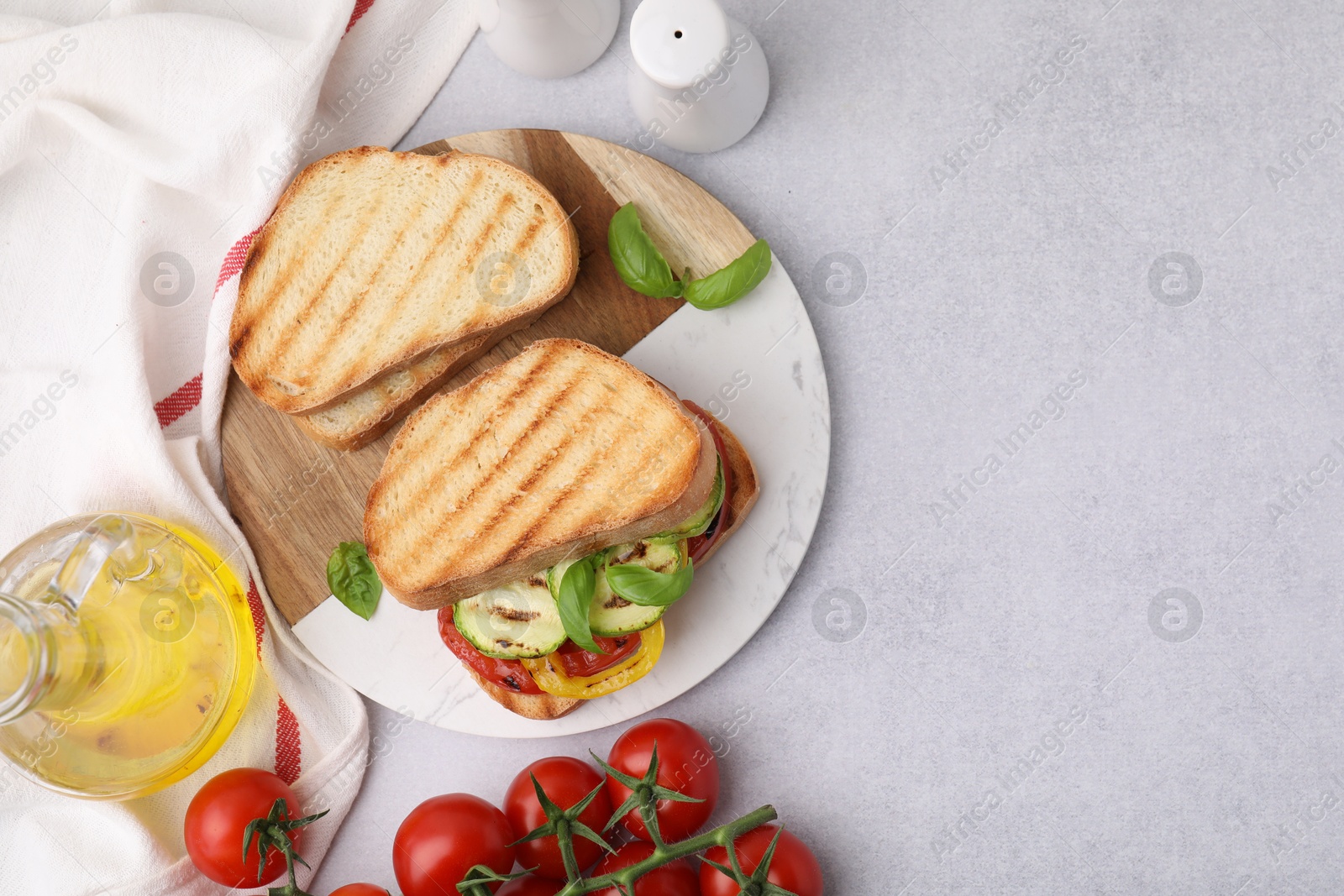 Photo of Tasty sandwiches with grilled vegetables, oil and spices on light textured table, flat lay. Space for text