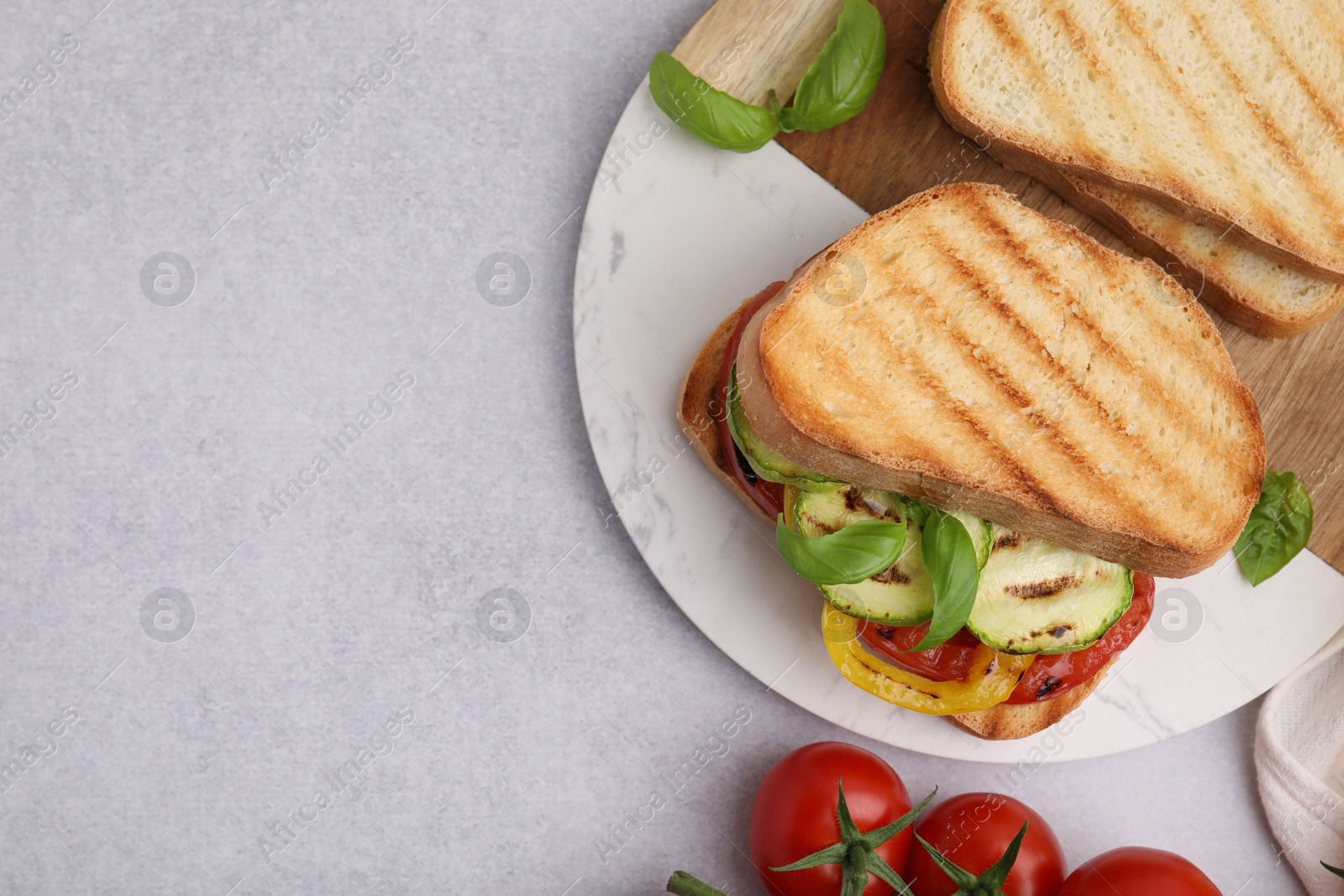 Photo of Tasty sandwiches with grilled vegetables and spices on light textured table, flat lay. Space for text