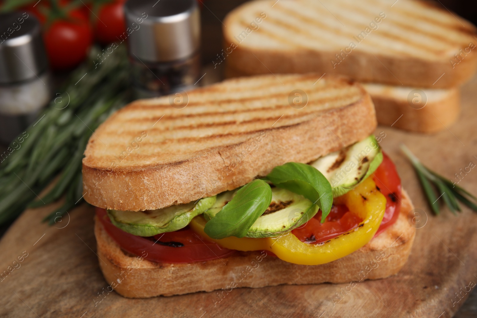 Photo of Tasty sandwich with grilled vegetables on wooden board, closeup