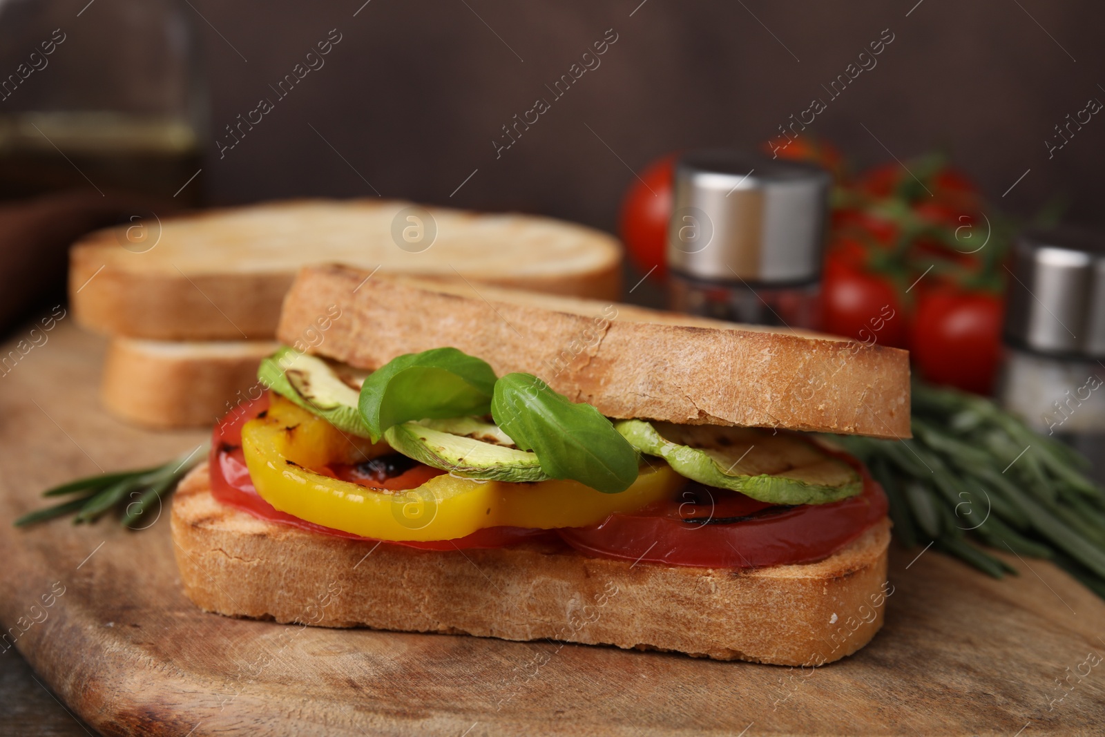 Photo of Tasty sandwich with grilled vegetables on wooden board, closeup