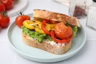 Photo of Tasty sandwich with grilled vegetables and cream cheese on white table, closeup