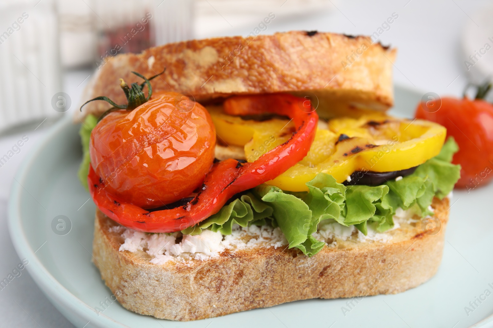 Photo of Tasty sandwich with grilled vegetables and cream cheese on table, closeup