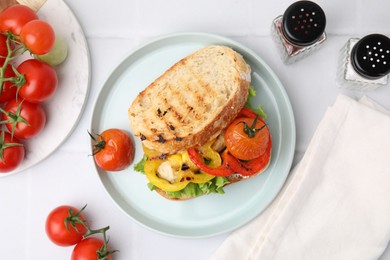 Photo of Tasty sandwich with grilled vegetables and spices on white tiled table, flat lay