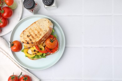 Photo of Tasty sandwich with grilled vegetables and spices on white tiled table, flat lay. Space for text