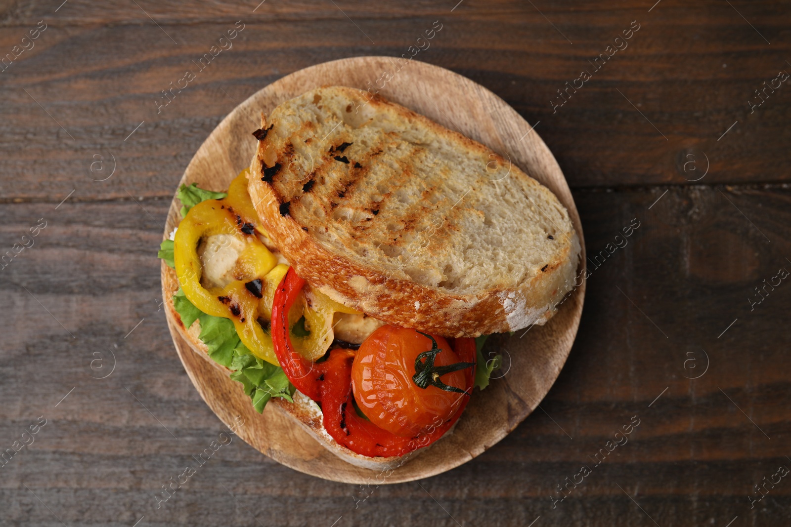 Photo of Tasty sandwich with grilled vegetables on wooden table, top view