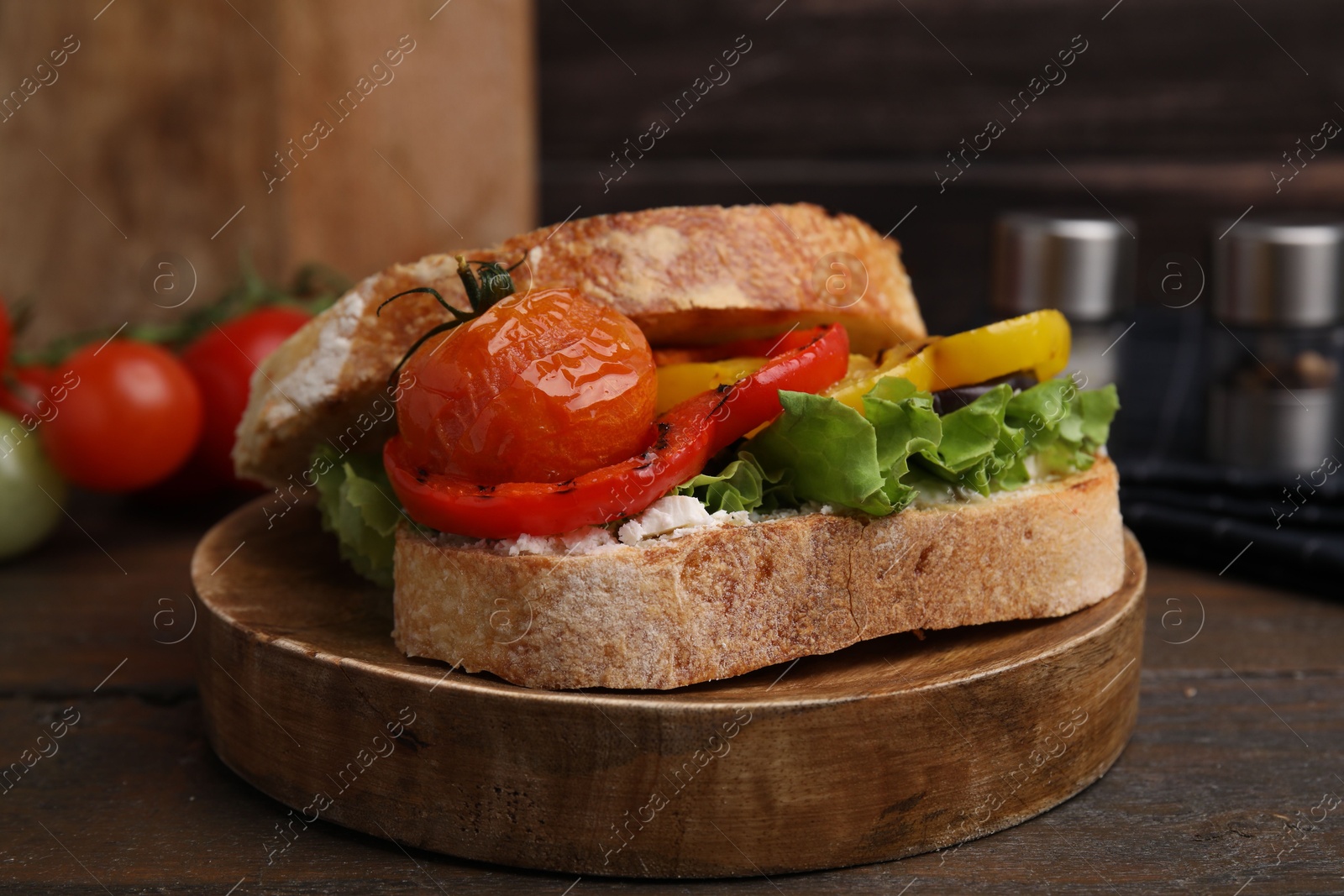 Photo of Tasty sandwich with grilled vegetables on wooden table, closeup