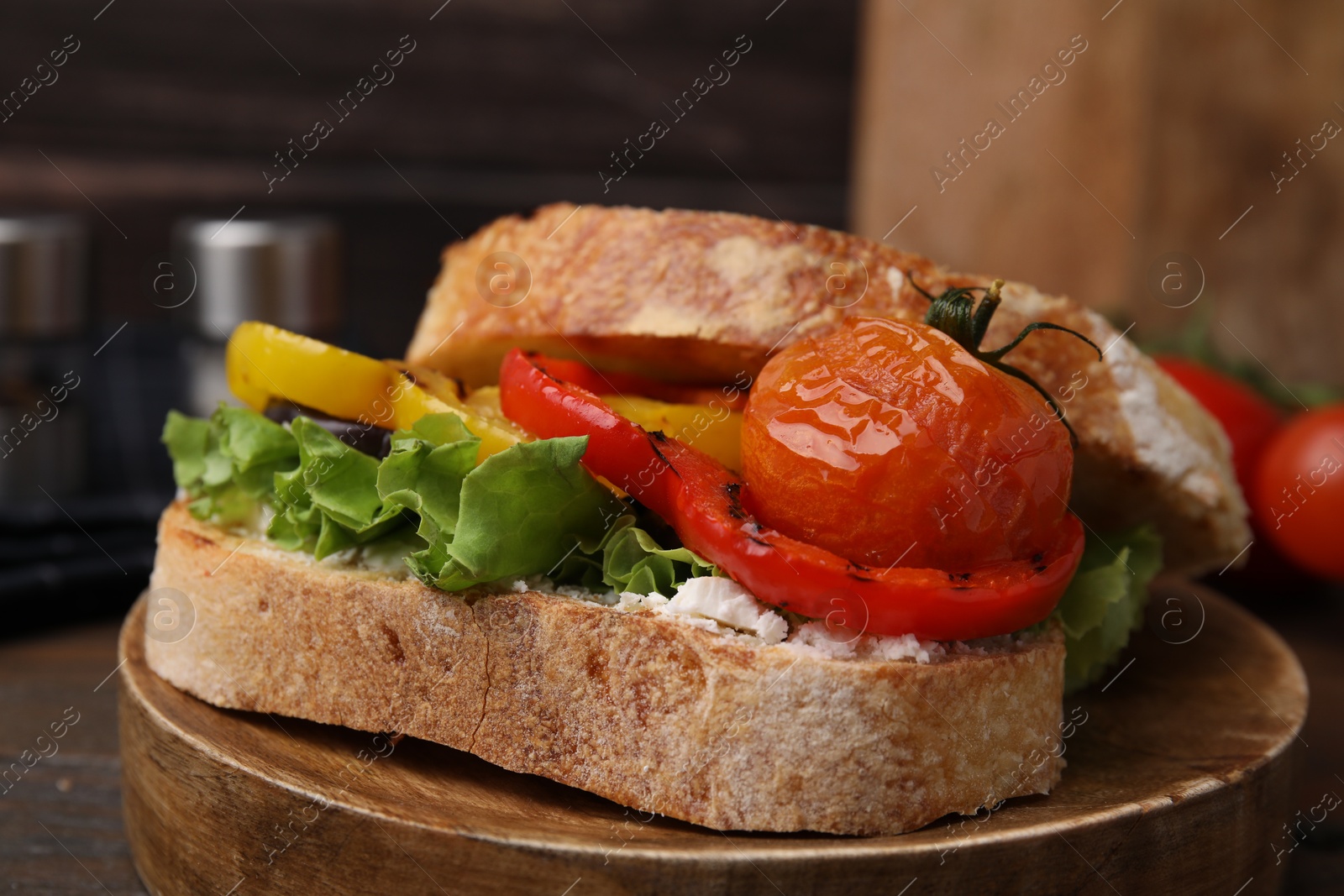 Photo of Tasty sandwich with grilled vegetables and cream cheese on wooden table, closeup