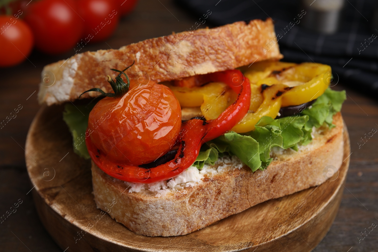 Photo of Tasty sandwich with grilled vegetables and cream cheese on wooden table, closeup