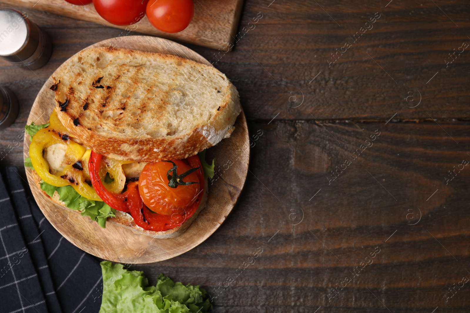 Photo of Tasty sandwich with grilled vegetables on wooden table, flat lay. Space for text