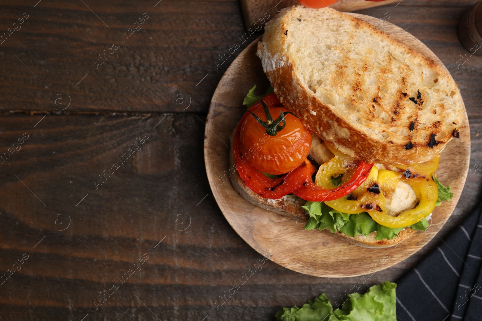 Photo of Tasty sandwich with grilled vegetables on wooden table, flat lay. Space for text