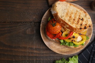 Photo of Tasty sandwich with grilled vegetables on wooden table, flat lay. Space for text